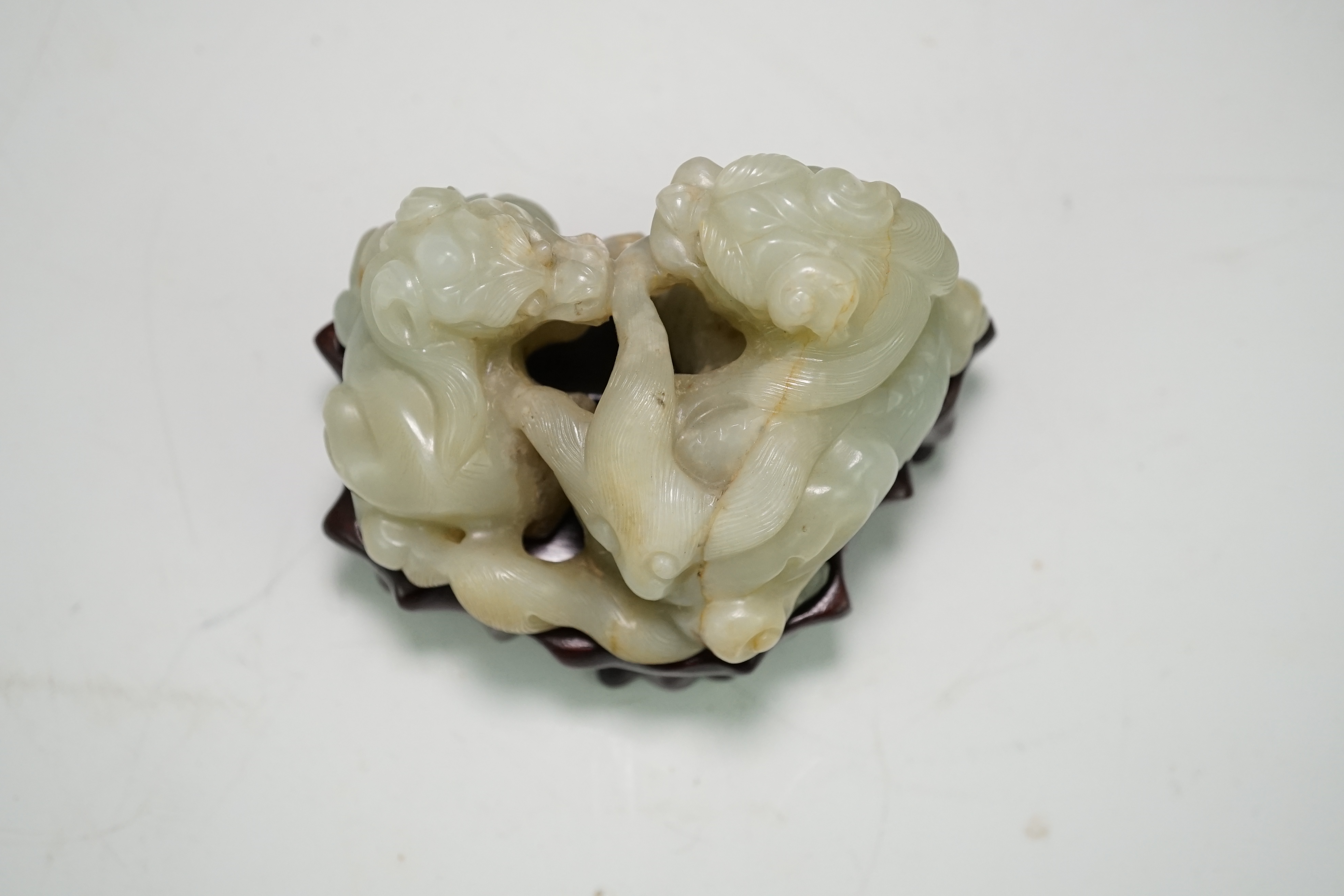 A Chinese celadon and russet jade group of two lion-dogs, 19th century